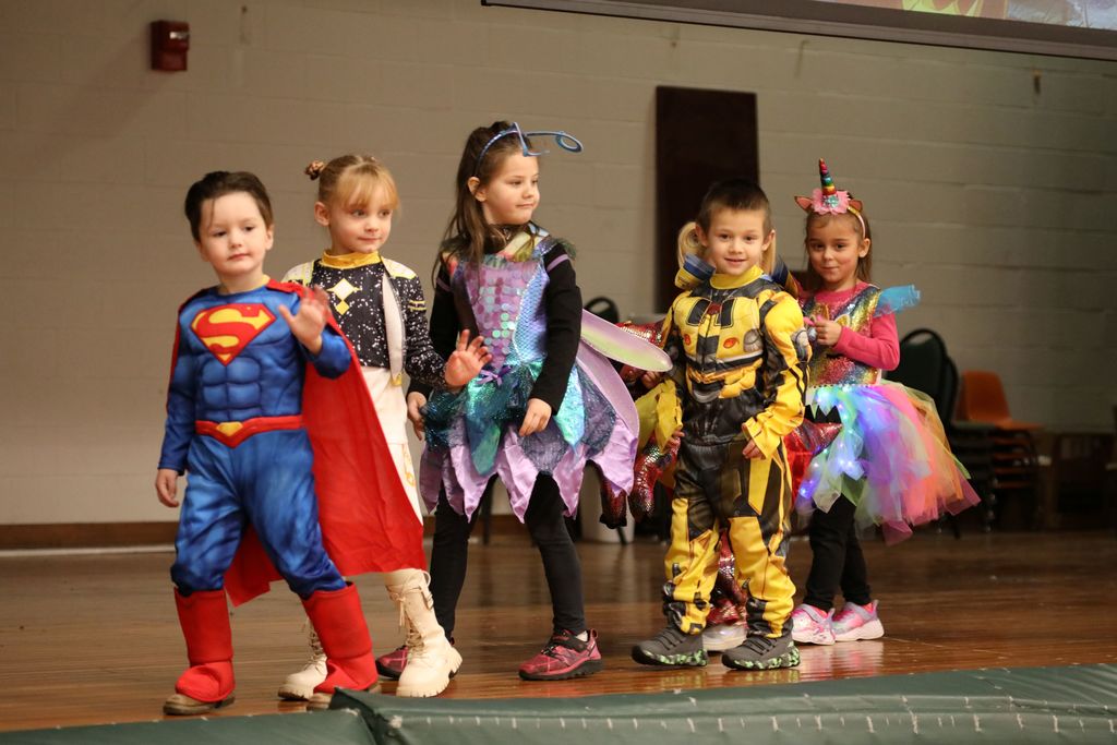 A group of 5 students walking across stage