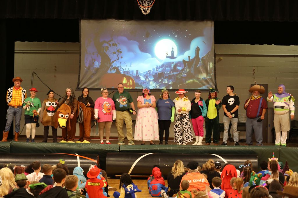 A group photo ofadmin,  staff, and teachers on stage