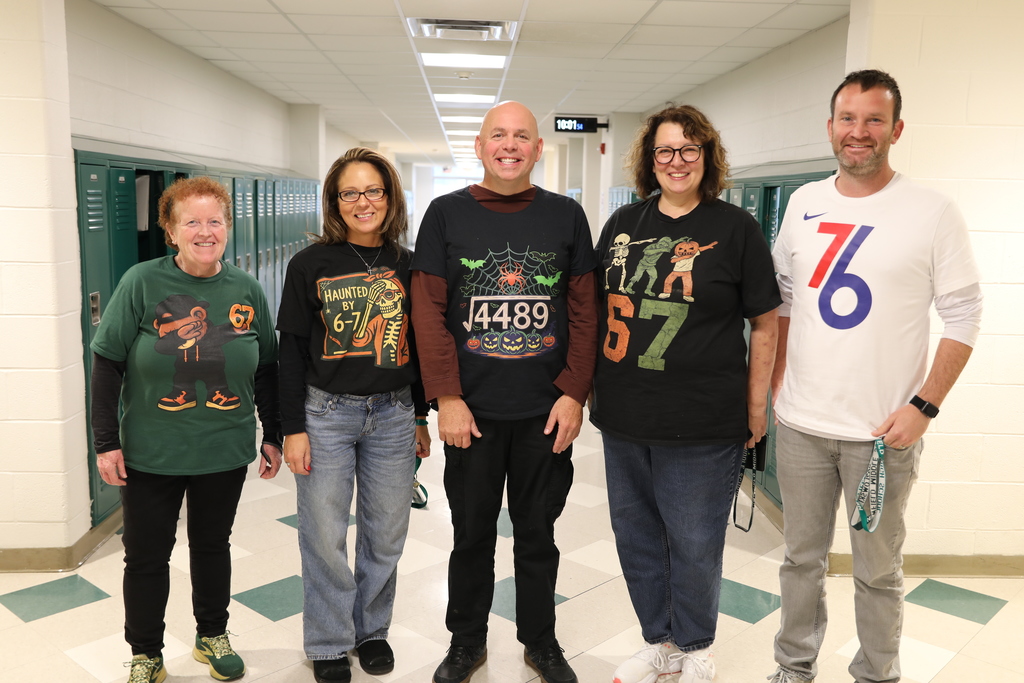 Faculty at the Middle School posing for a picture in all their "67" shirts
