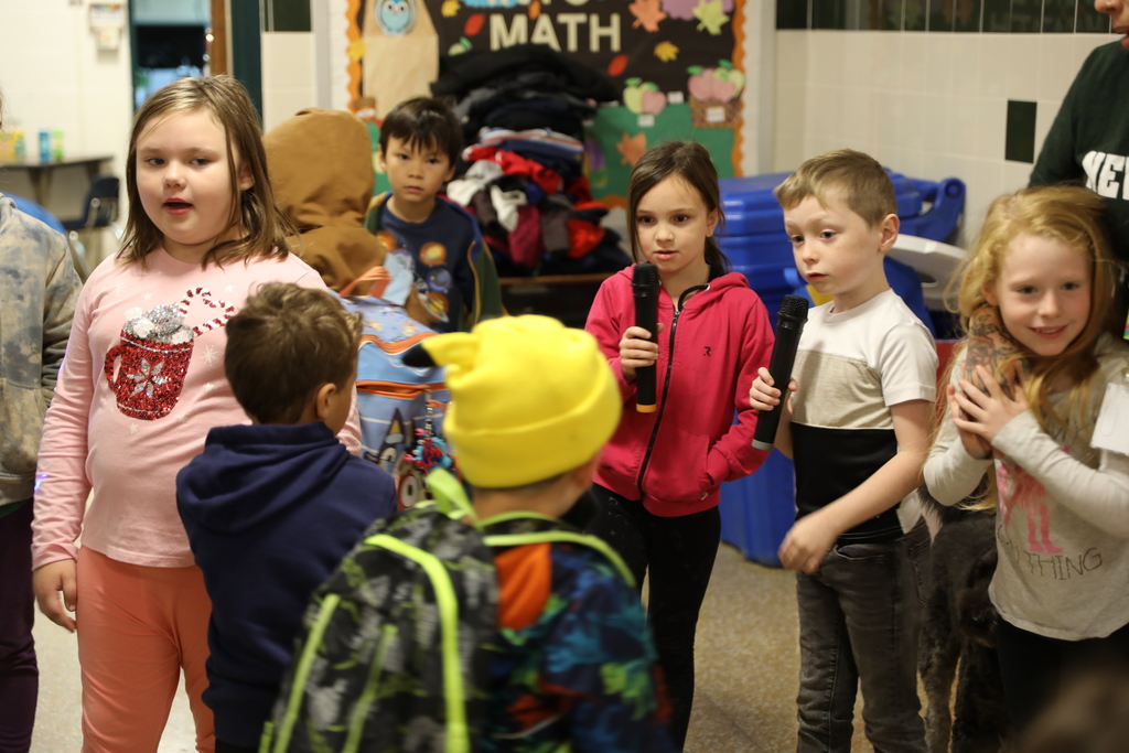 Two students holding the mics standing among other students