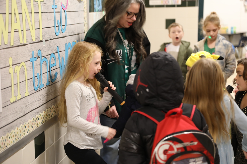 A student singing as a bunch of other students gather around