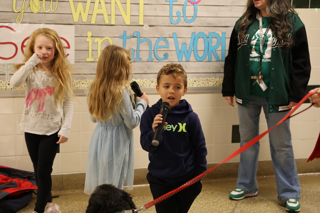 Two students singing while another dances