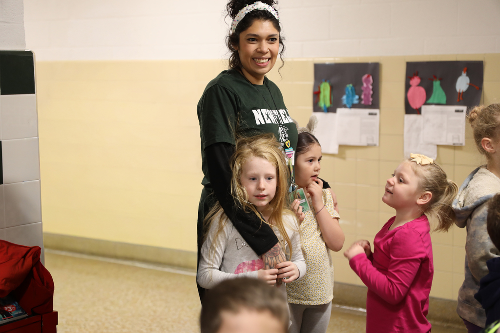 An adult staff member with 3 students in the hall