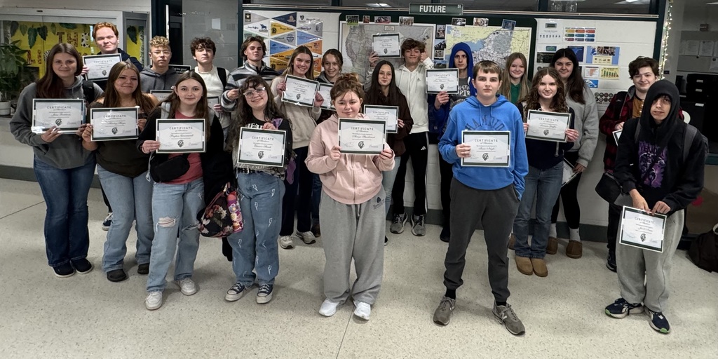 A group of students holding up their certificates for a photo