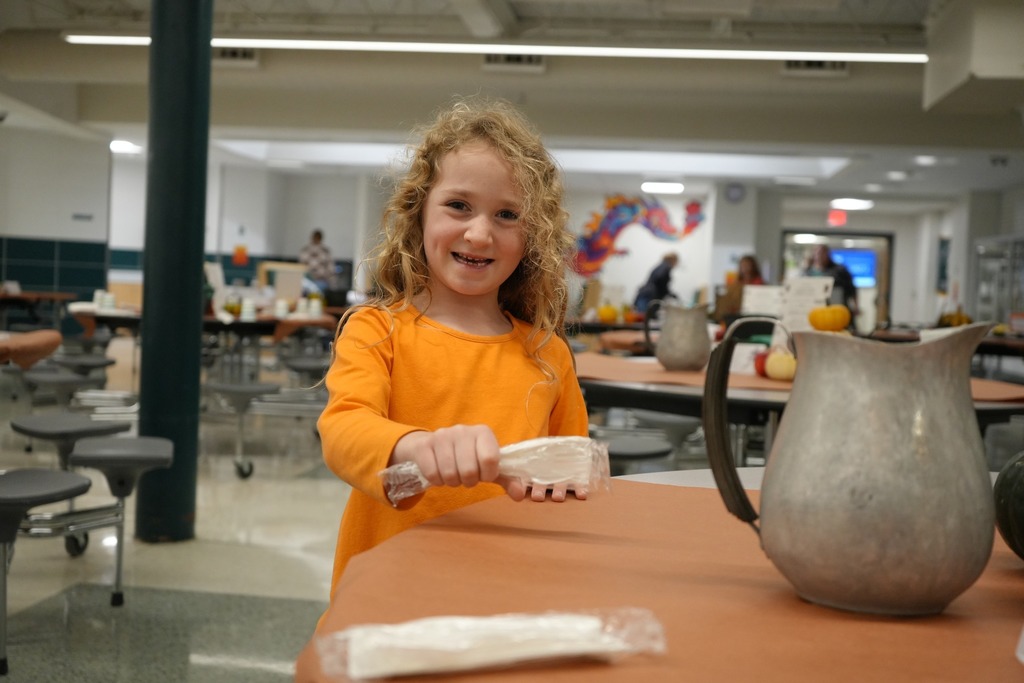 Student setting table at 2nd annual harvest dinner