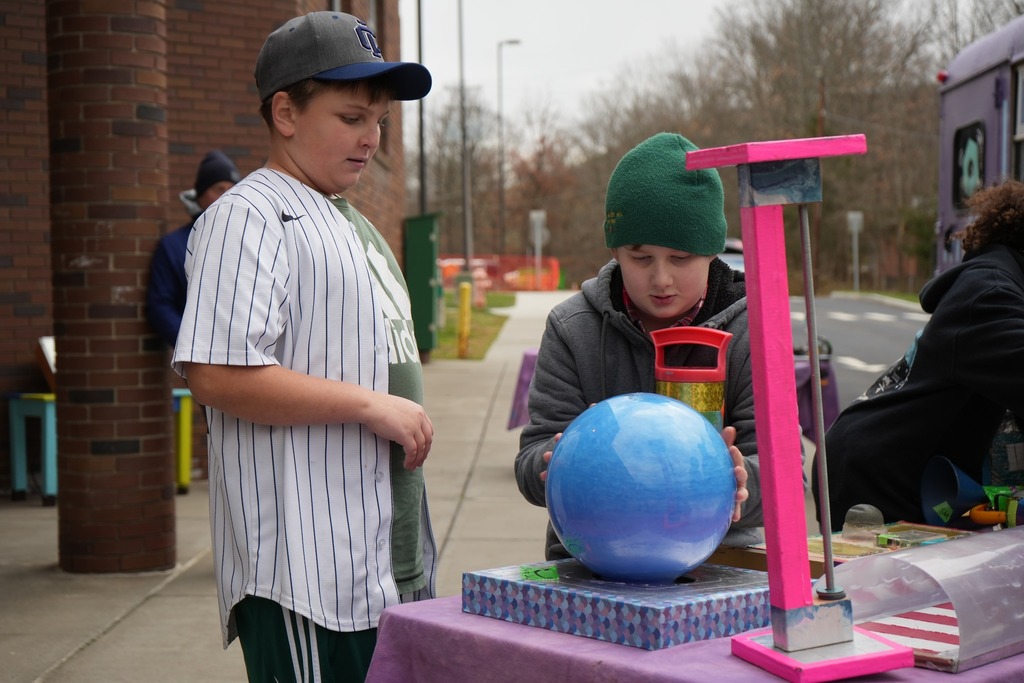 two students looking at blue ball