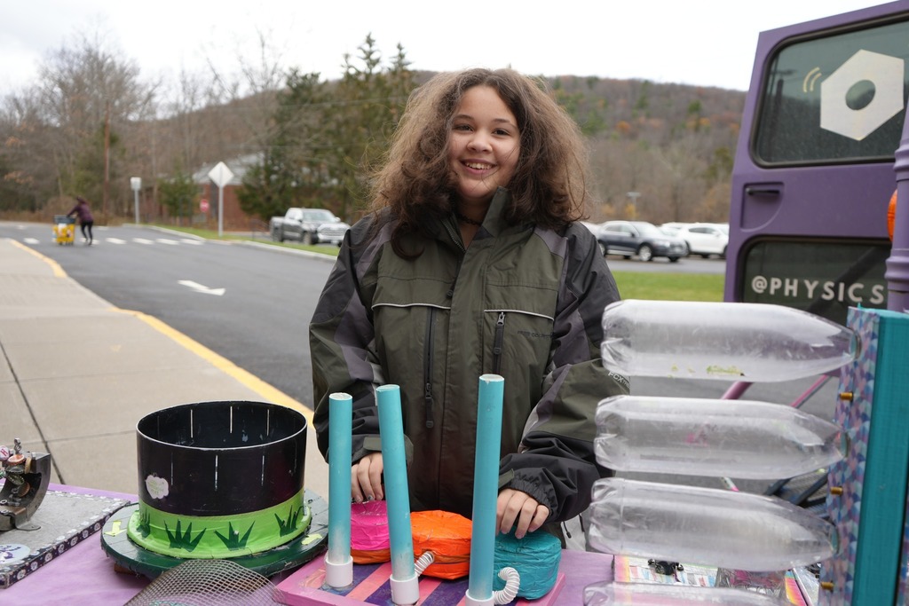 student smiling over the objects on the table