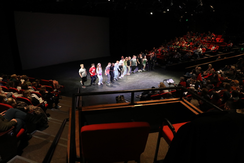 a group of students on stage performing a song