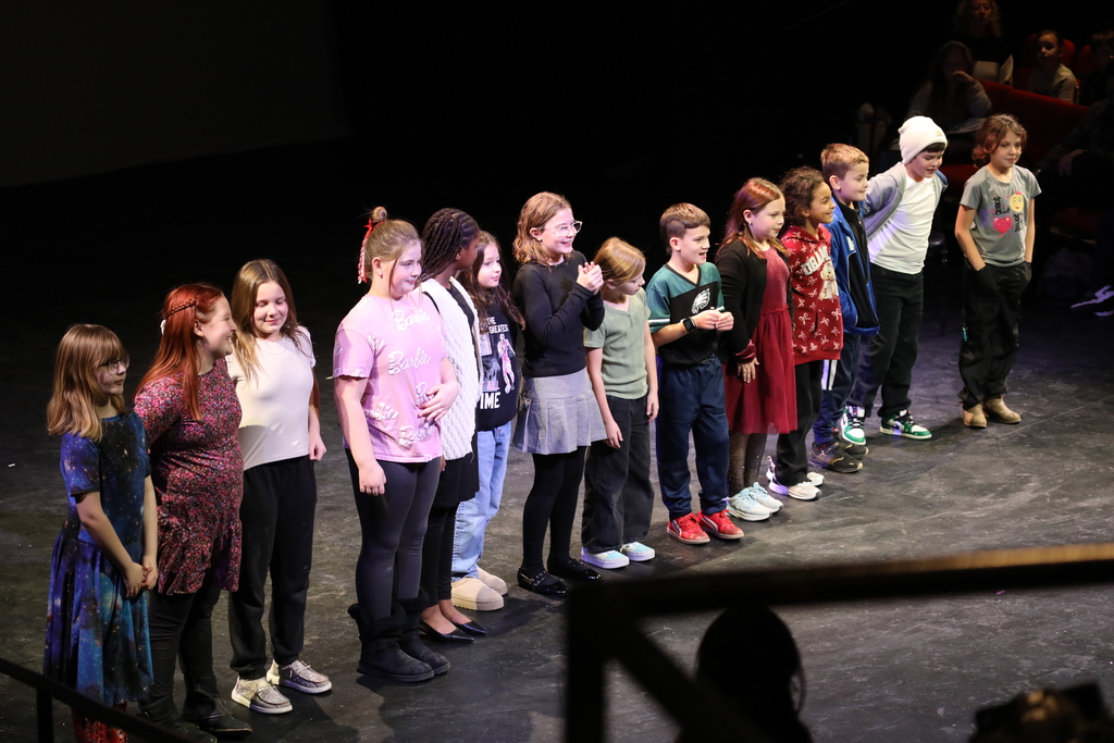 a group of students on stage performing a song