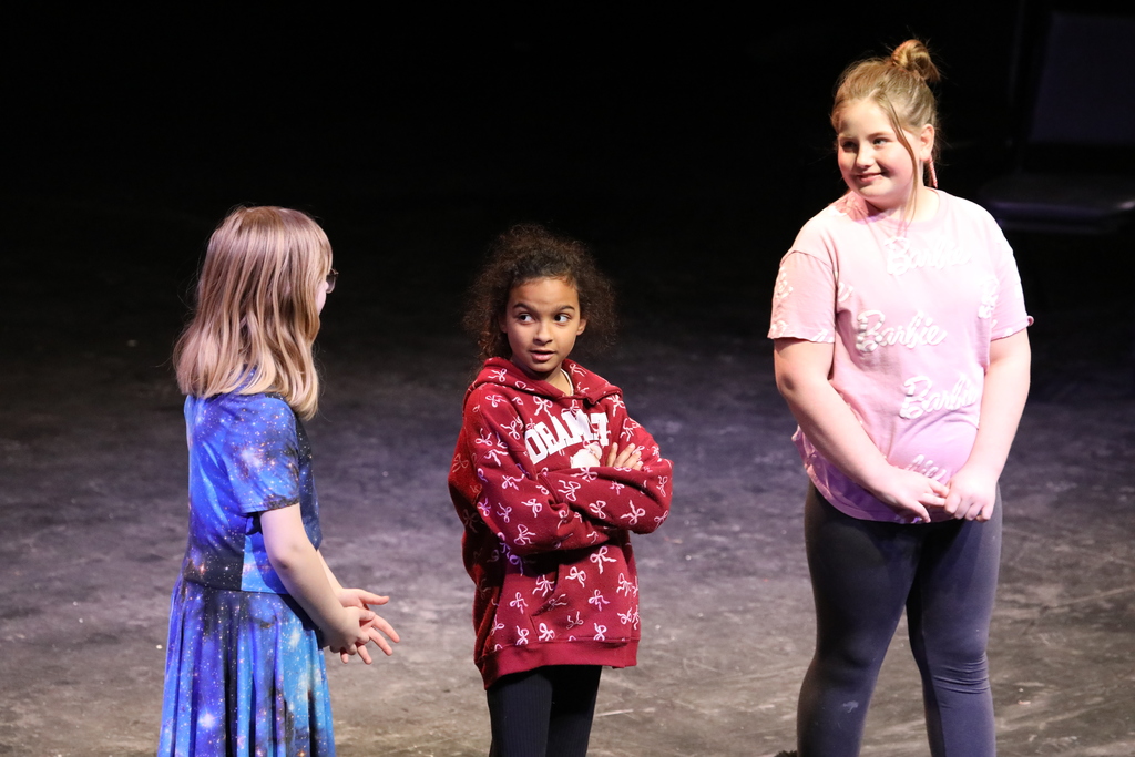 three students acting out their scene in a play