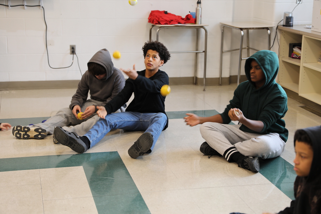 a large group of students practicing juggling 