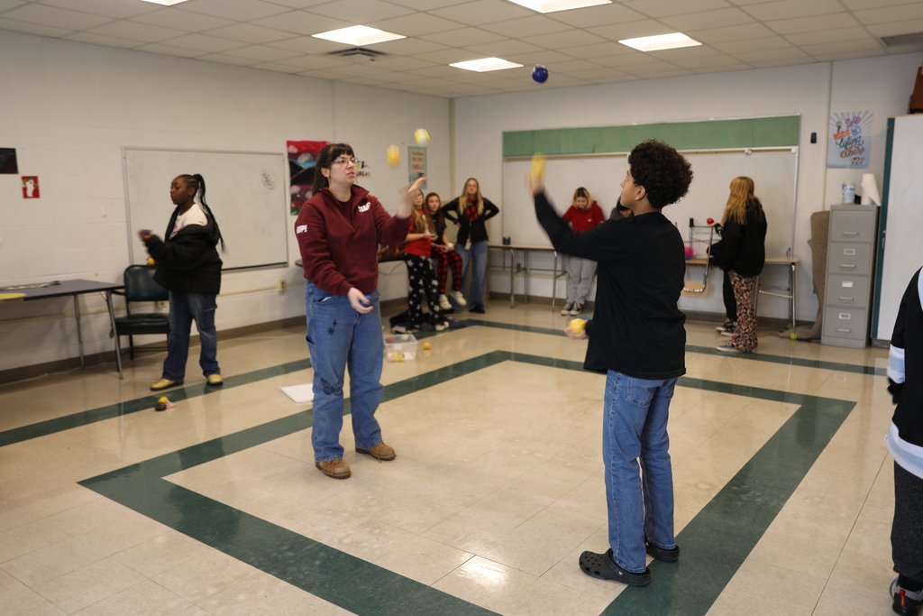 A student and the presenter practice juggling 