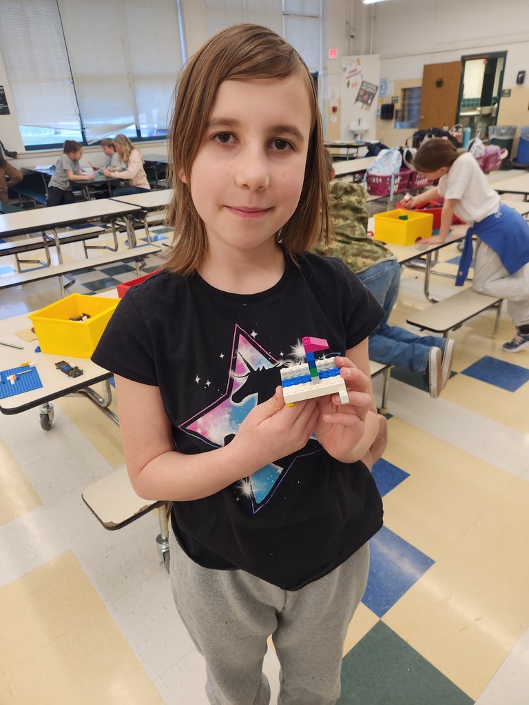 Several students work together at a table building LEGO structures using challenge cards during the After School Program.