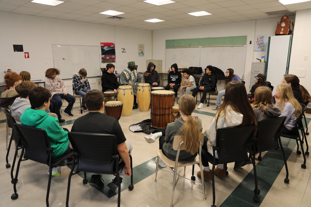 A room full of students learning about drumming