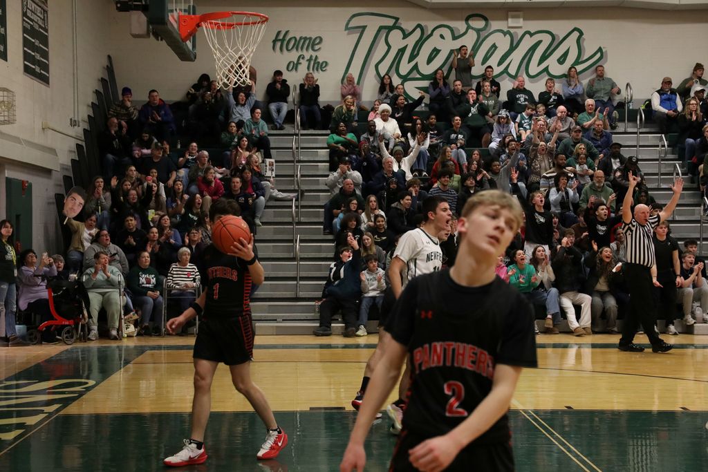 the opposing team looking upset as Newfield scores a basket