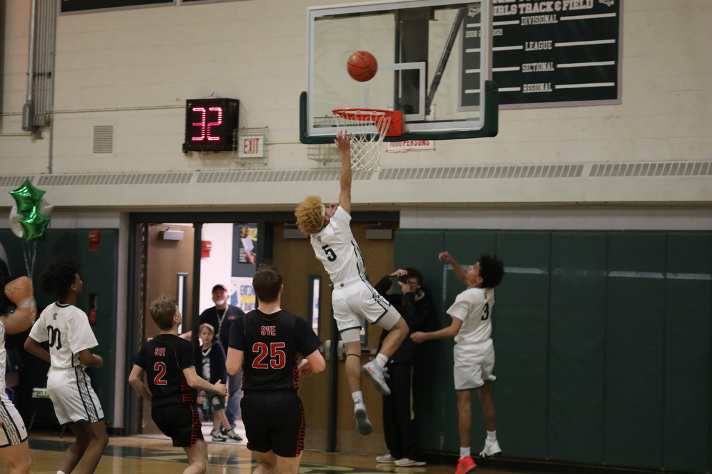 a student leaping to shot a basket during the game