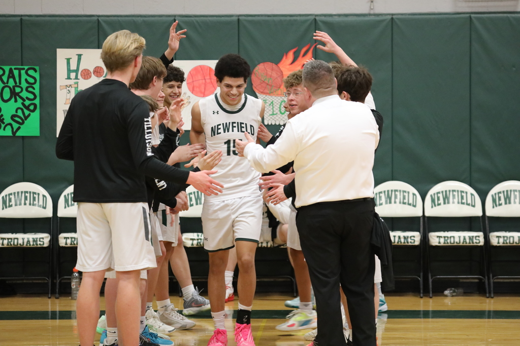the team cheering one a member as he runs onto court