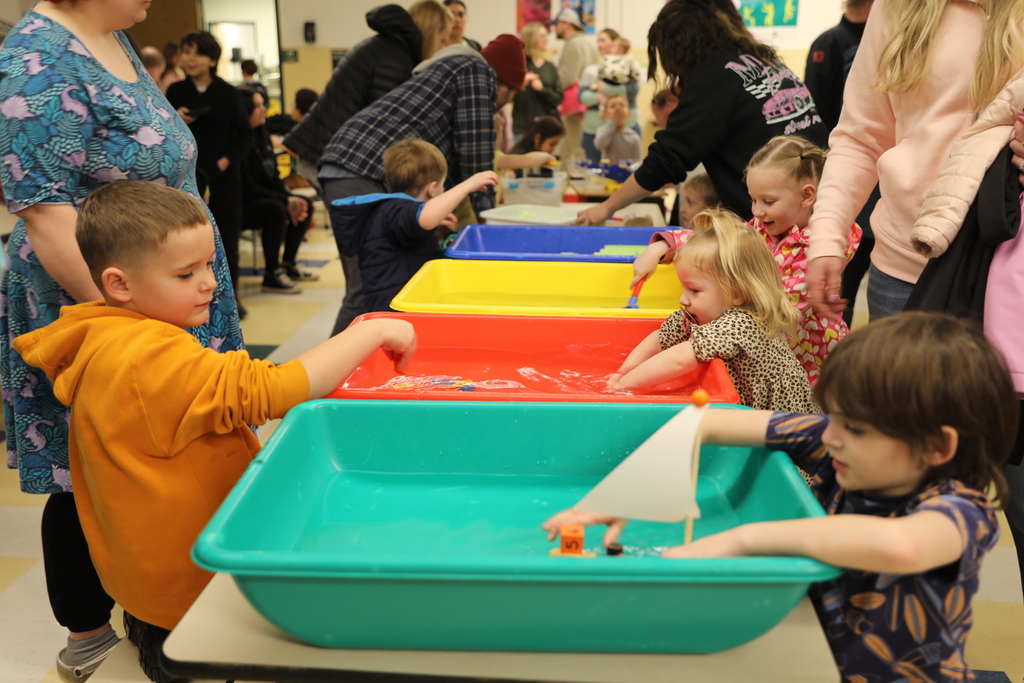 a bunch of kids lined up to play in the water tubs