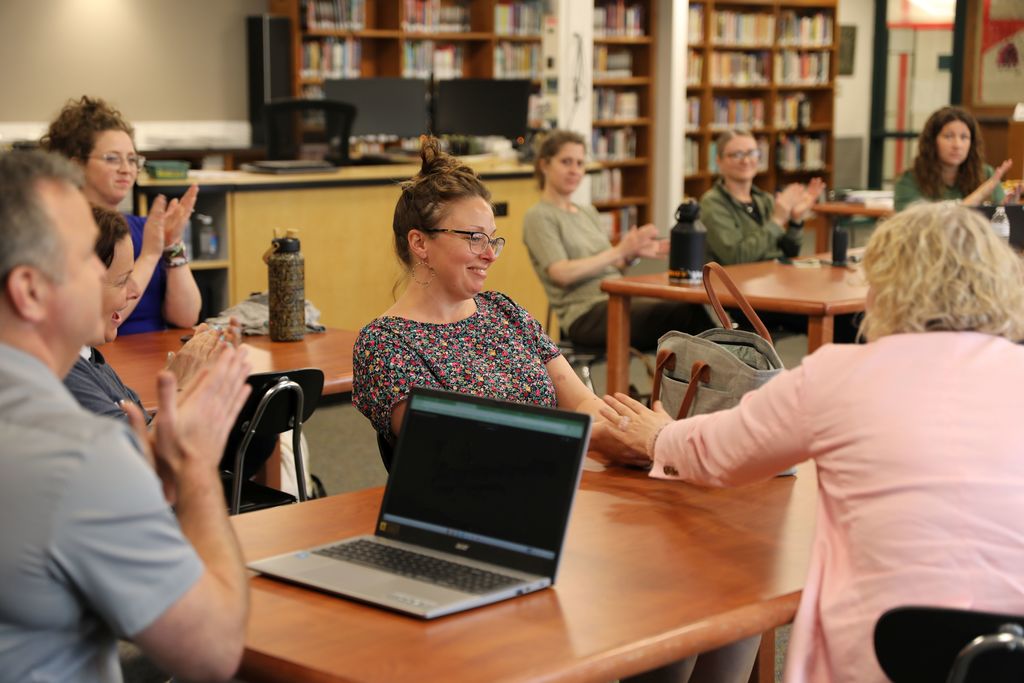 Liz Kozlowski receives the NYS Senate Award "Educators Inspiring a Generation" at the Newfield High School Library during a Faculty meeting