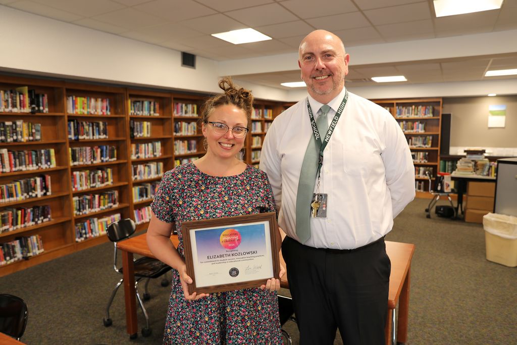 Liz Kozlowski receives the NYS Senate Award "Educators Inspiring a Generation" at the Newfield High School Library during a Faculty meeting