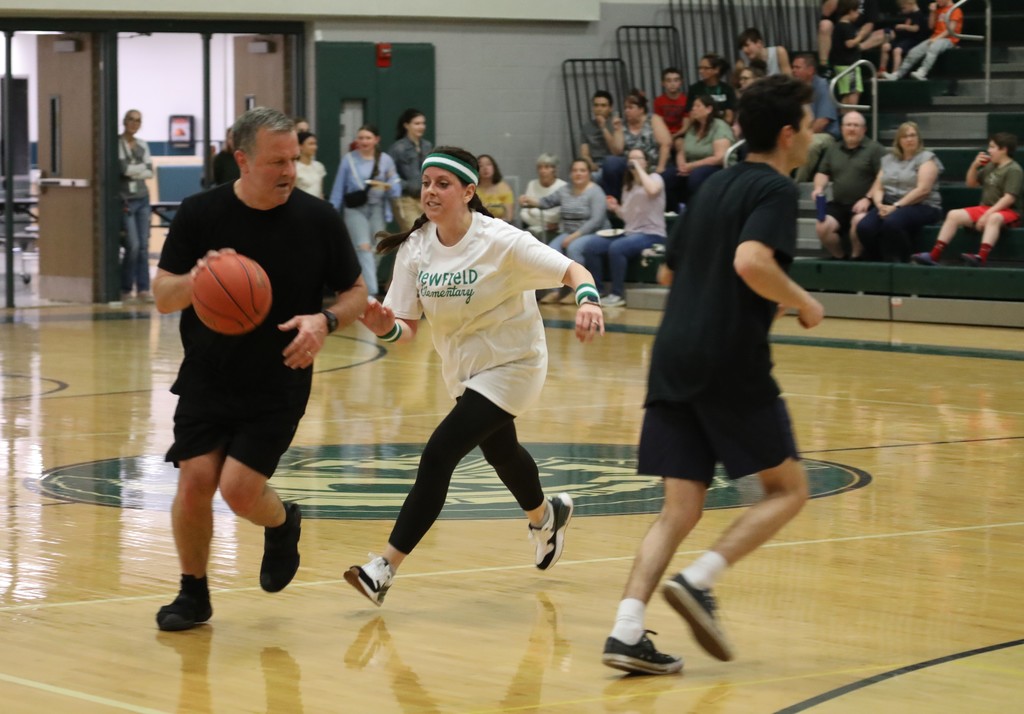 one staff member chasing the other trying to get the ball