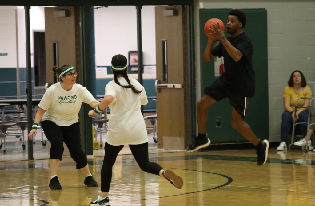two staff members trying to defend from another jumping up with the ball