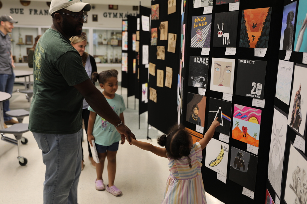 A parents and kids looking at the student art