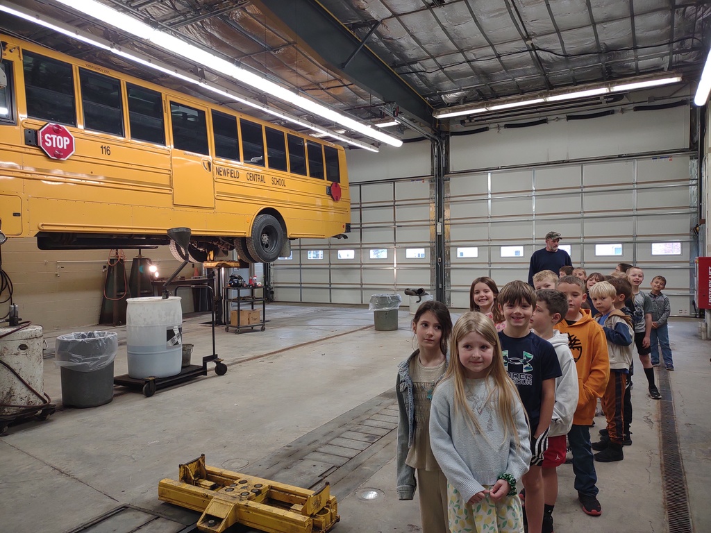 students in a line looking at the bus garage