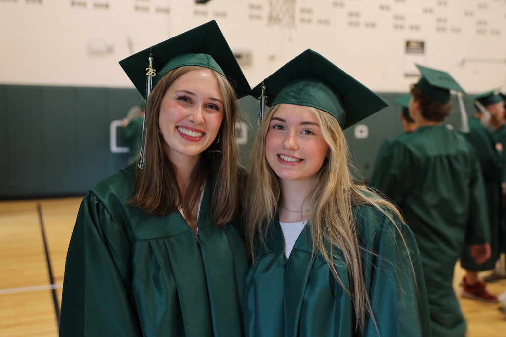 two seniors pose for the camera
