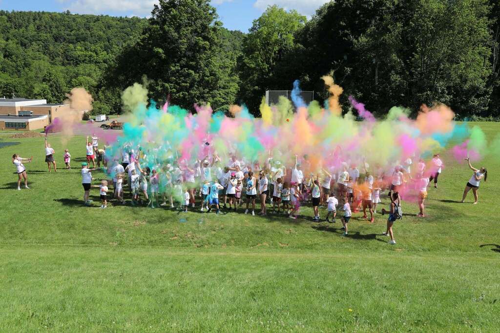 a large group of people throwing colors into the air