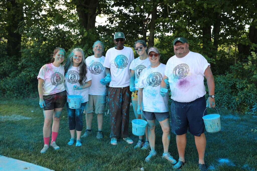 a group of staff members posing for the camera during the color run