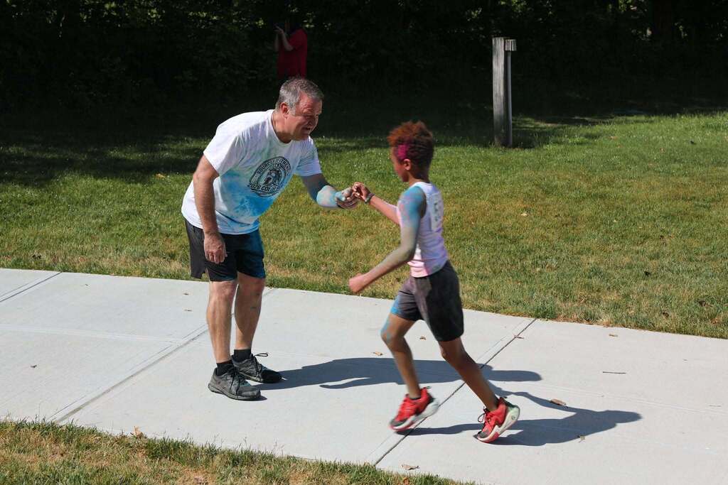 A student getting a fist bump from a staff member