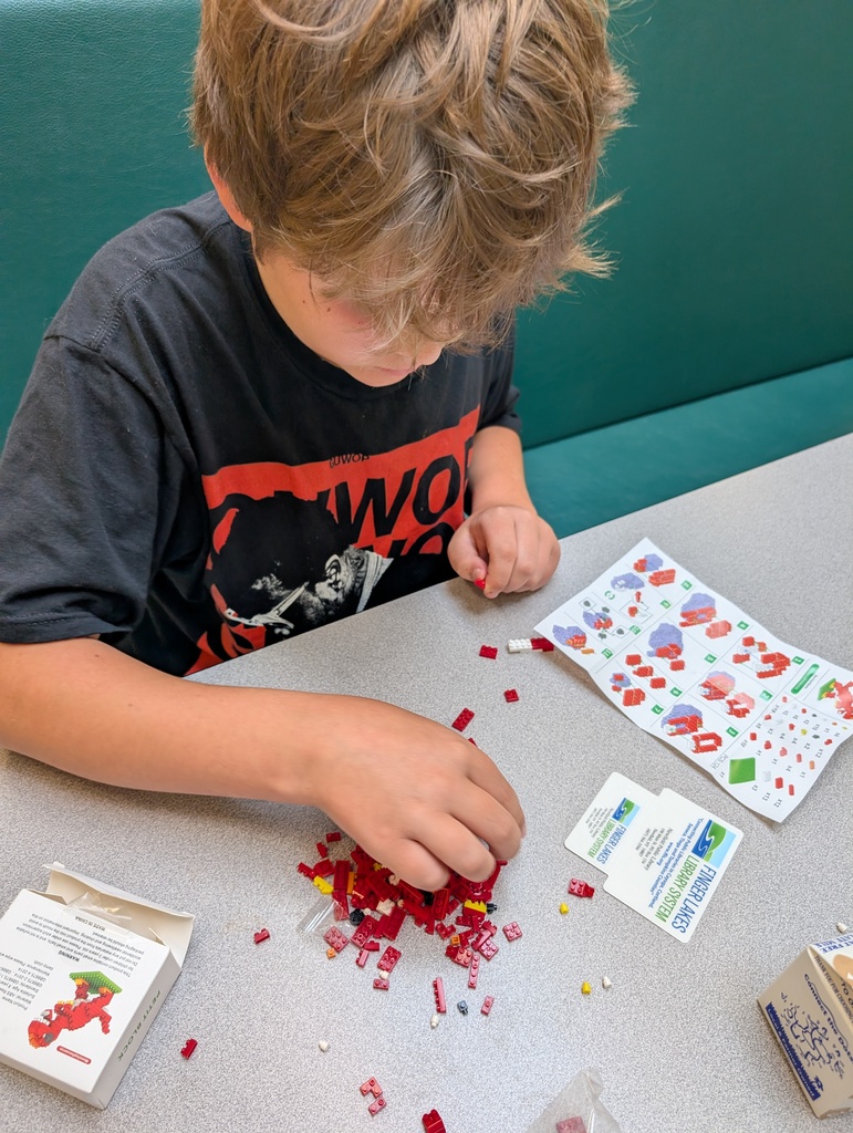 a child's hand playing with some toys while looking at a library card