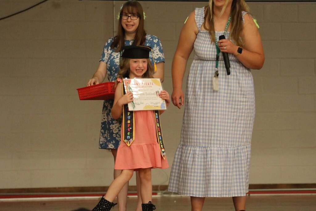 a student holding up their certificate 