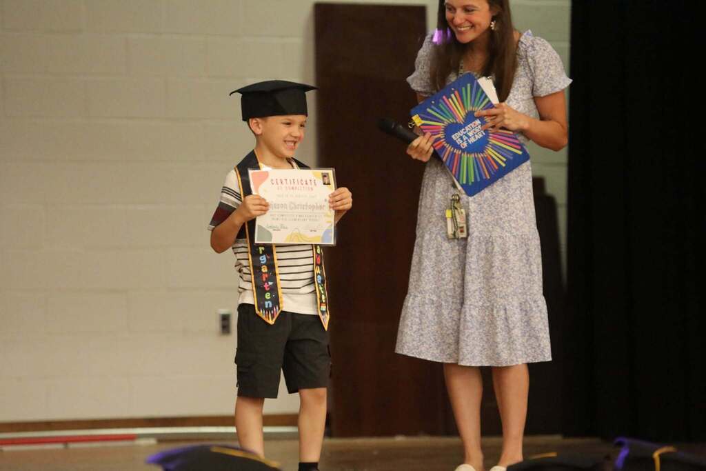 a student holding up their certificate 