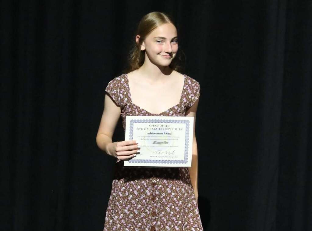 a student holding up their certificate 
