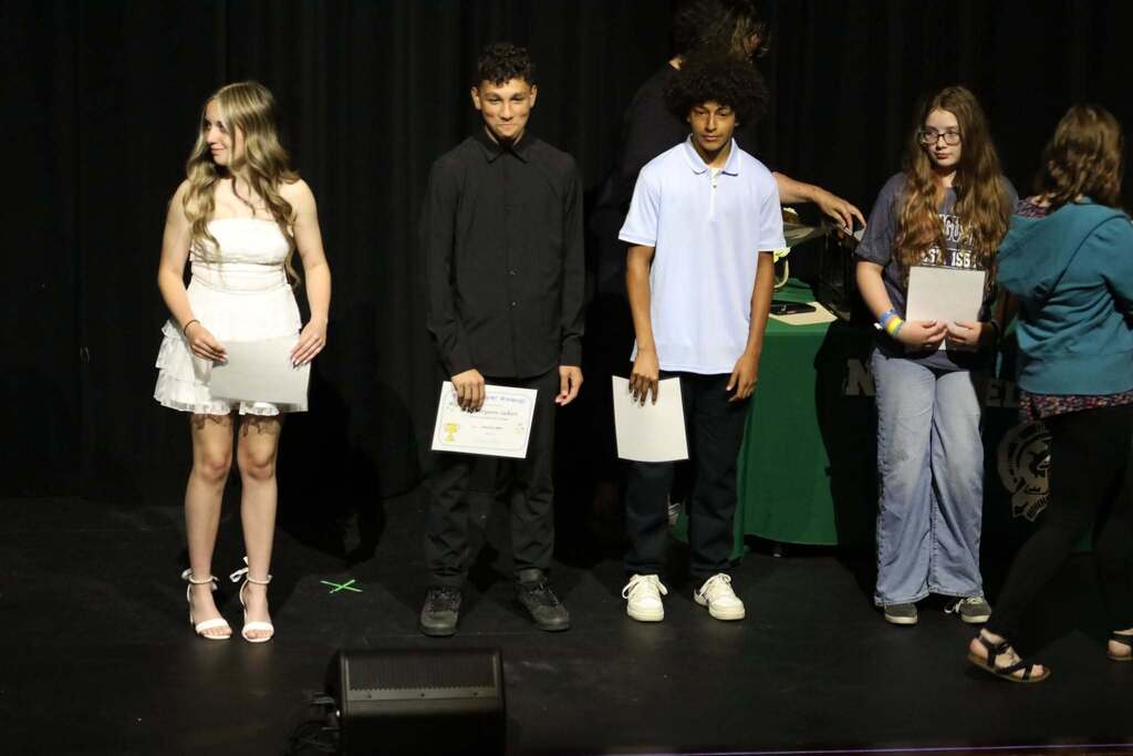 Four students standing with their awards