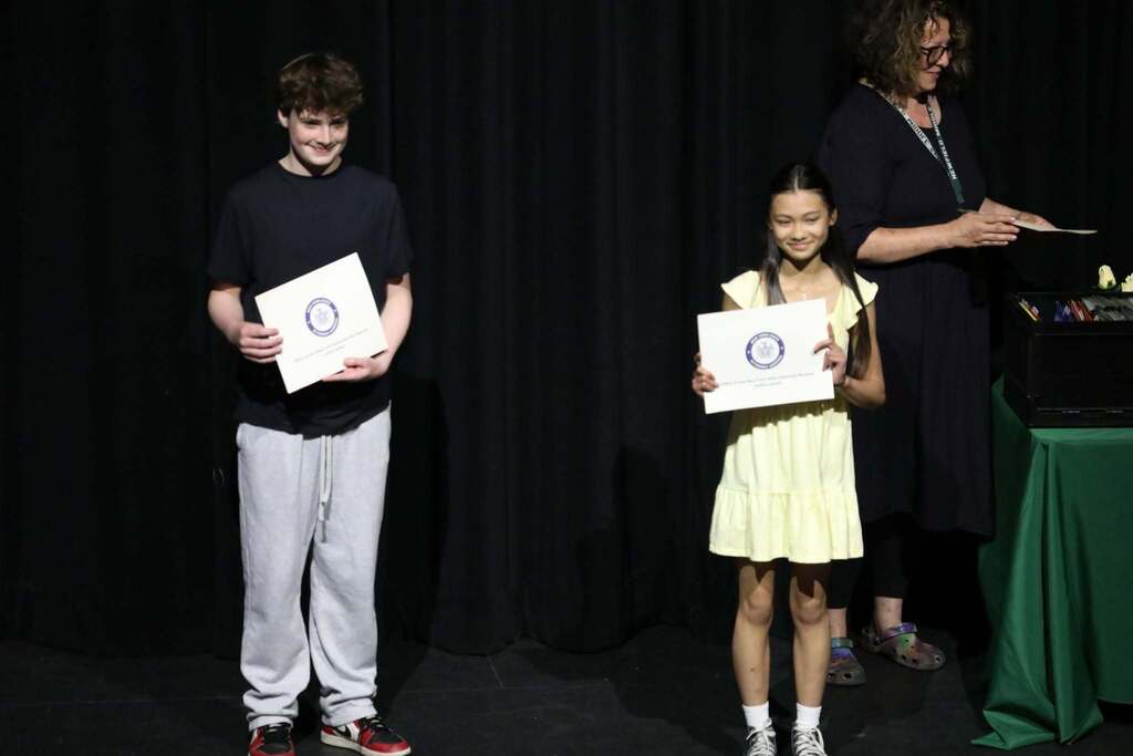 Two students holding up their awards