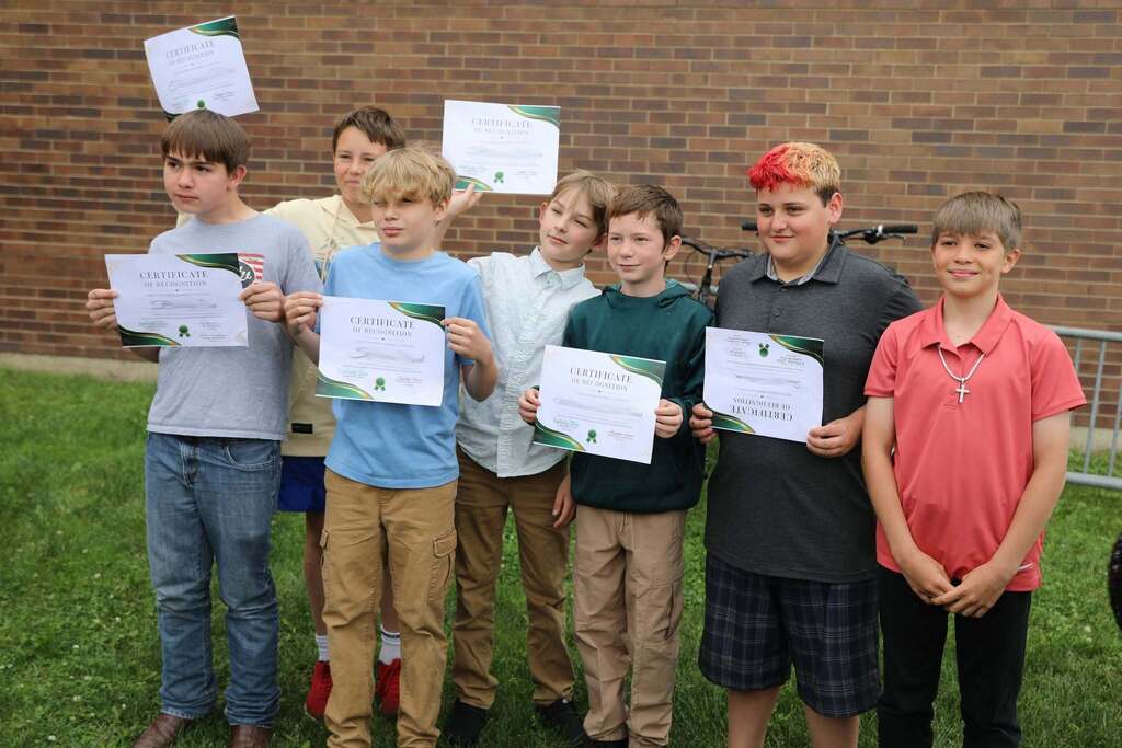 a group of students holding up their certificates 