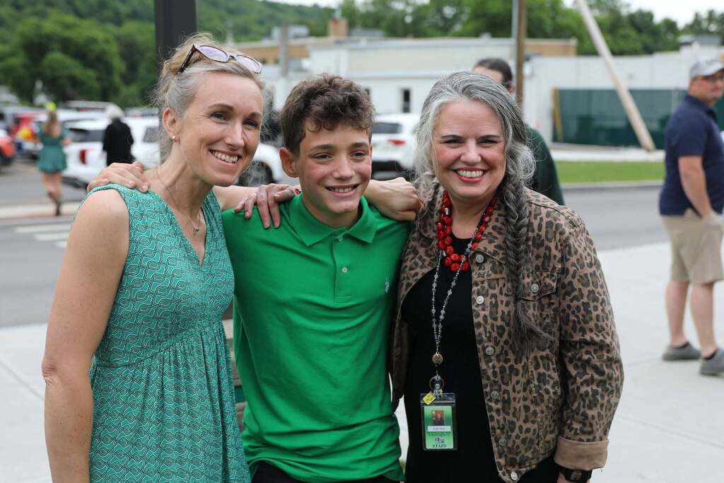 a student posing with two staff members 