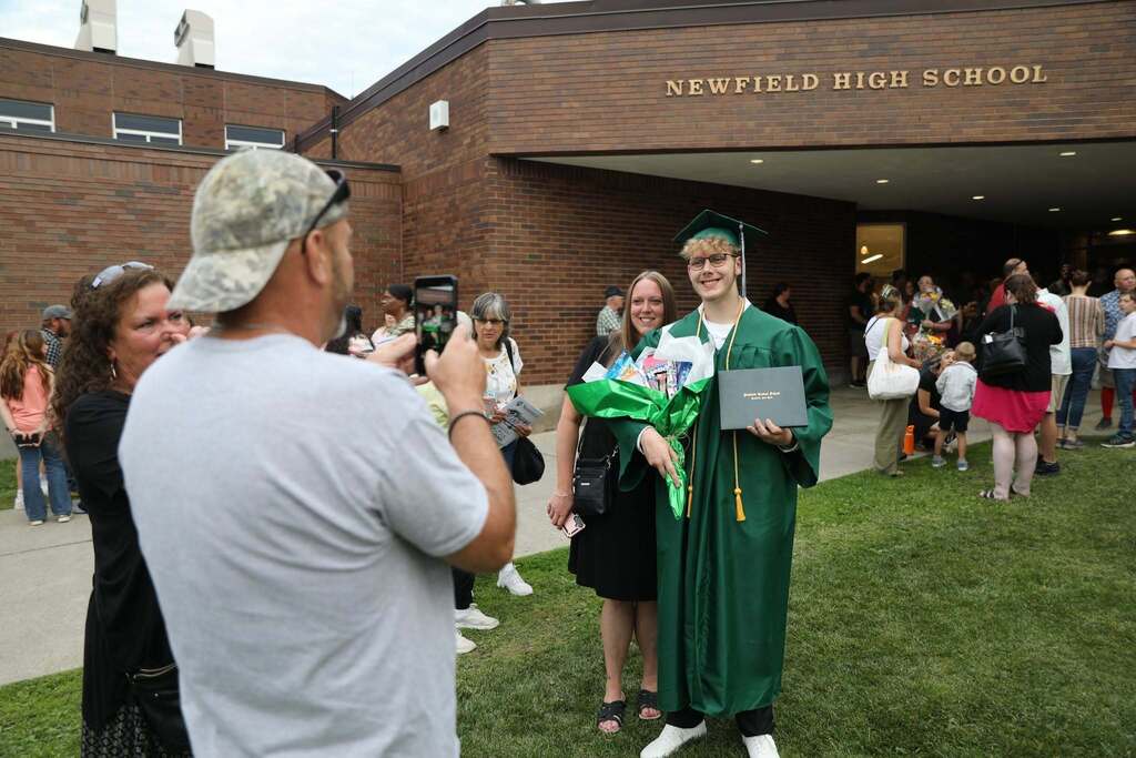 a family taking a photo for their son in front of the school