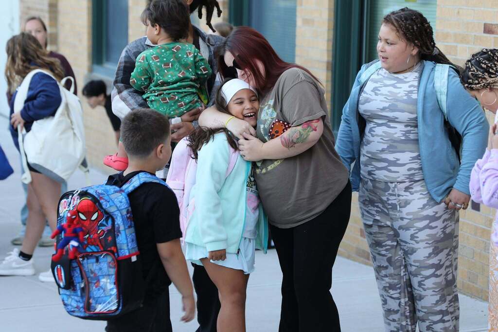 a parent hugging their student before school