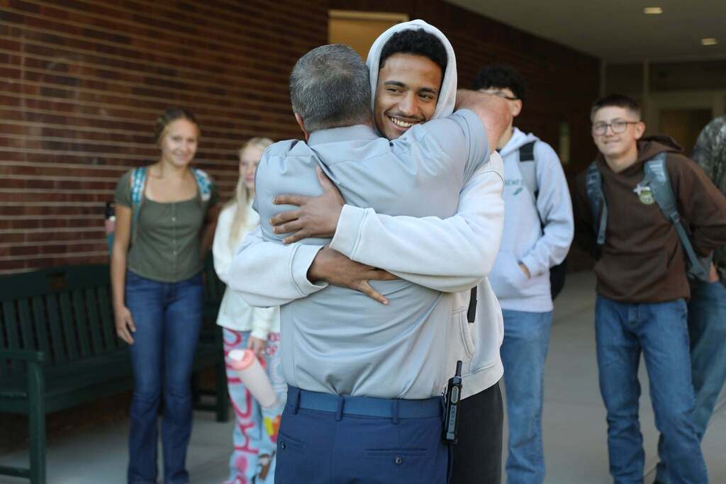 a student hugging a staff member