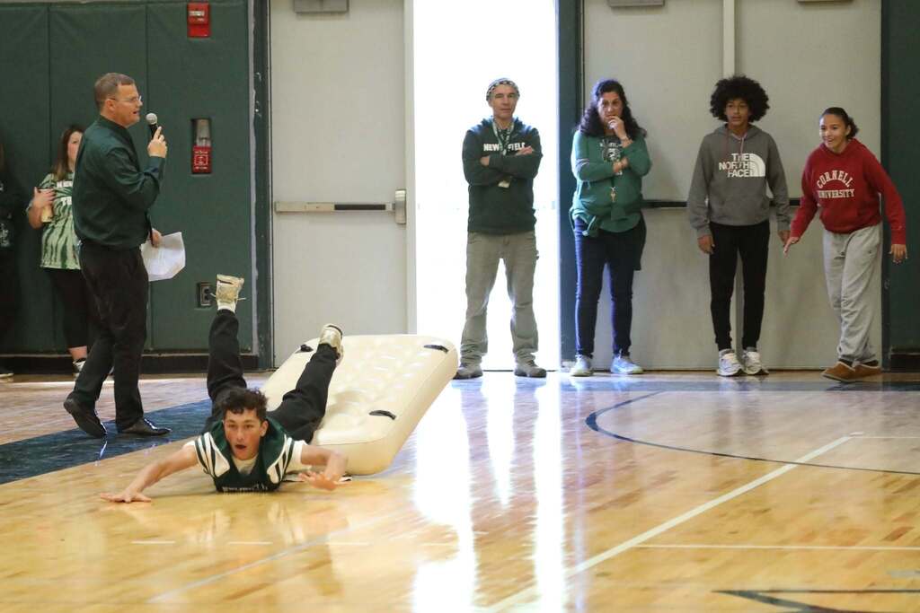 a student slipping off a blow up mattress during a race