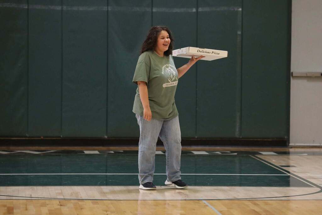 the winning student smiling as the last one standing with a pizza box