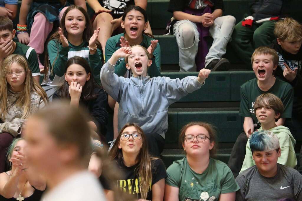 students in the stands cheering during the pep rally
