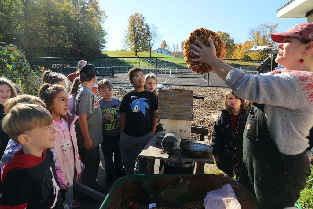 the teacher holding up the apple pieces after being pressed