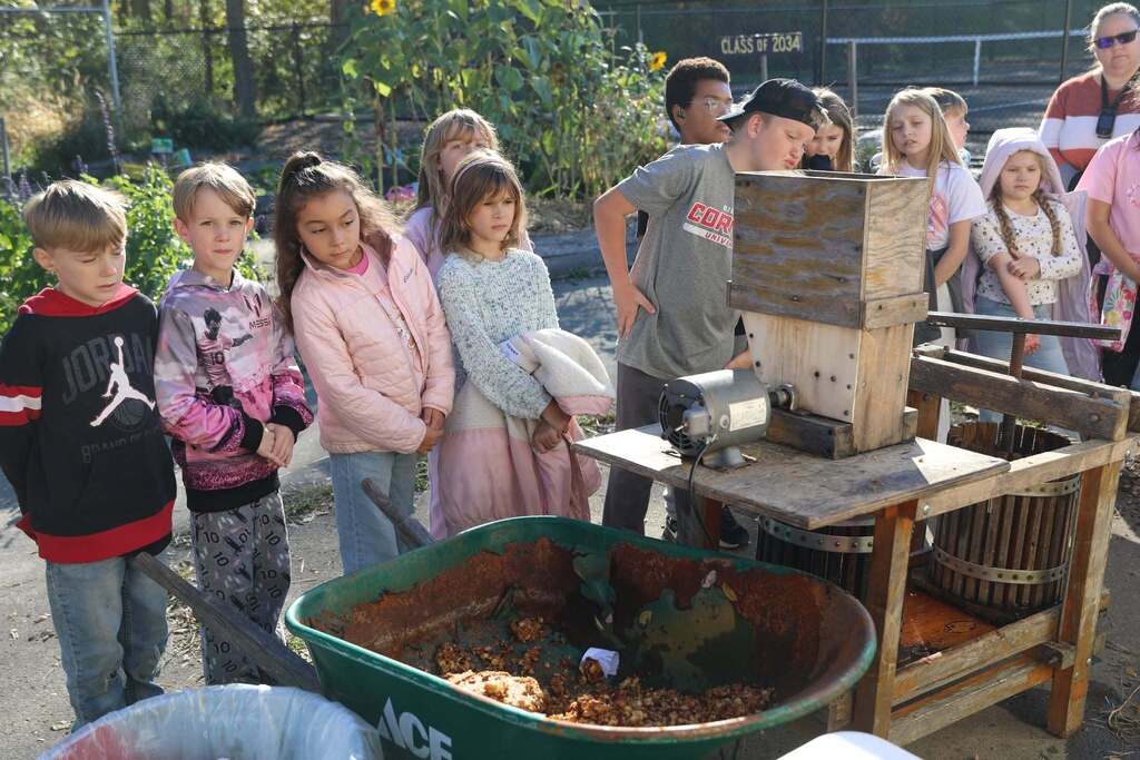 students looking at the apple press