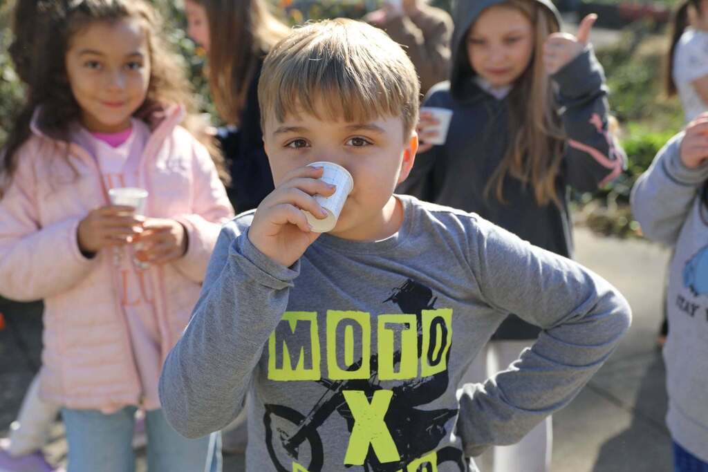 a student drinking from his cup of cider