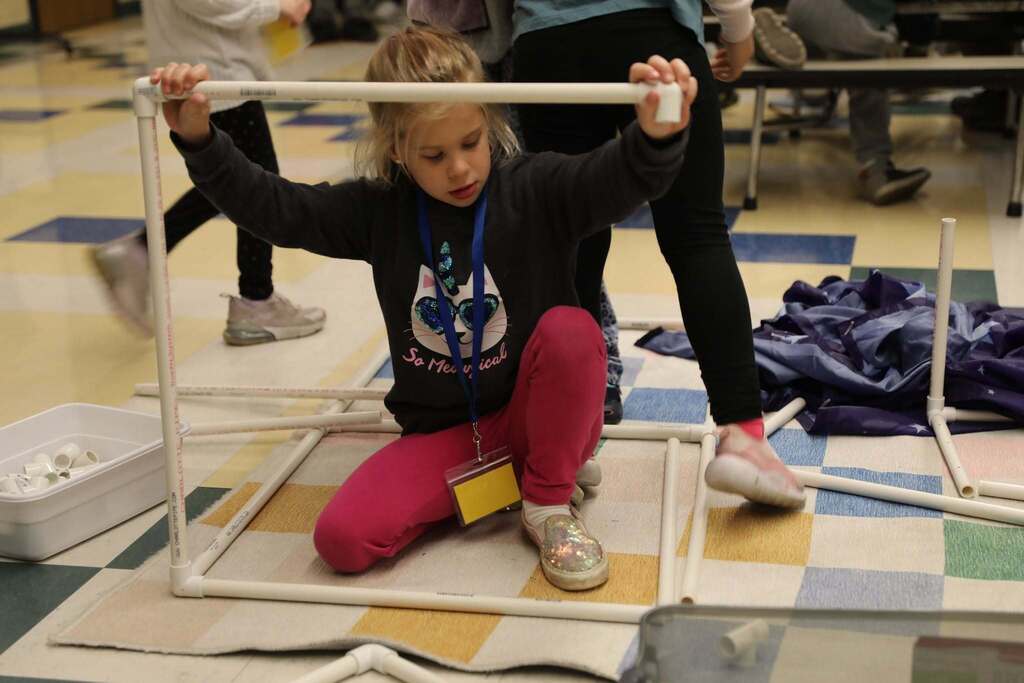 a student working to put together some pvc piping